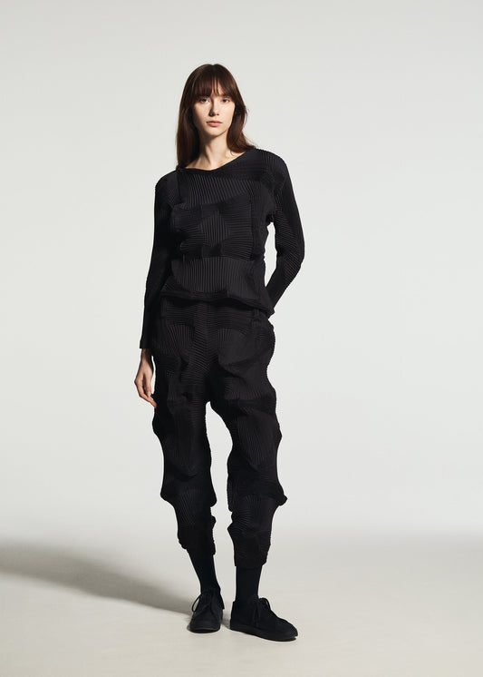 A model wears the A-POC ABLE ISSEY MIYAKE TYPE-O 003 BK trousers.