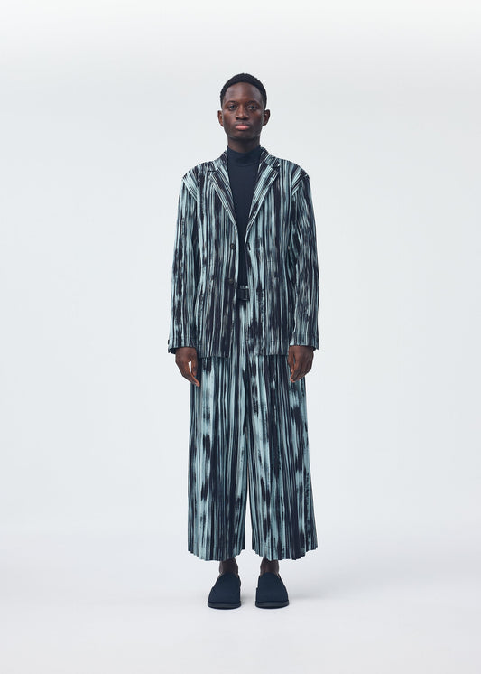 A model wears the HOMME PLISSÉ ISSEY MIYAKE BRUSHSTROKE STRIPE trousers.