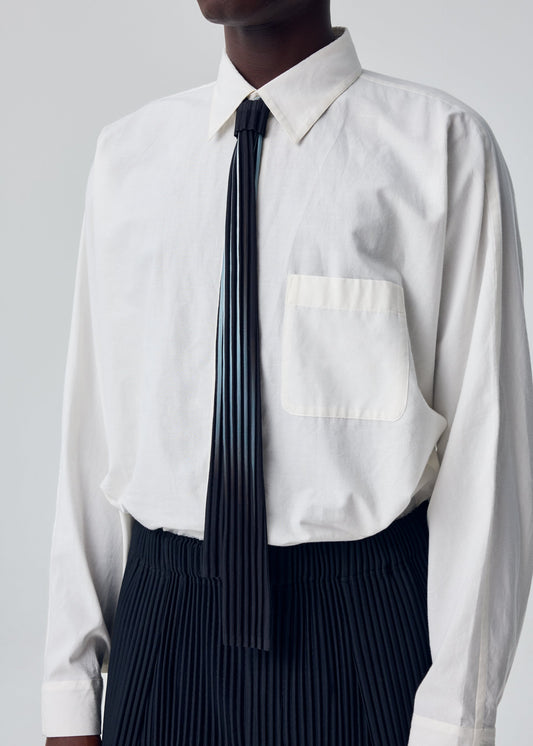 A model wears the HOMME PLISSÉ ISSEY MIYAKE IN THE SHADOW PLEATS TIE tie.