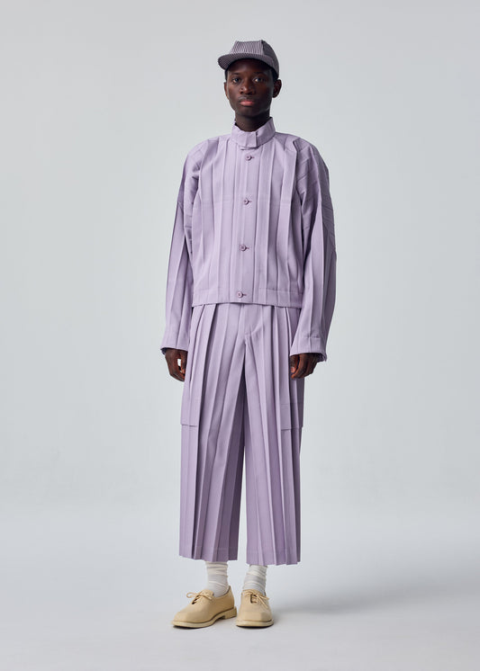 A model wears the HOMME PLISSÉ ISSEY MIYAKE EDGE ENSEMBLE trousers.