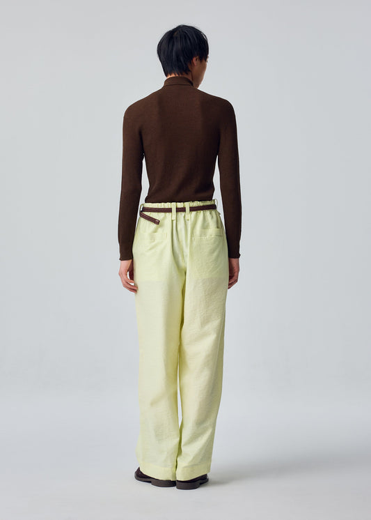 A model wears the HOMME PLISSÉ ISSEY MIYAKE OPACITY trousers.