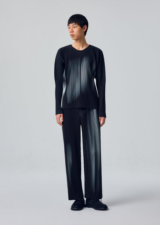 A model wears the HOMME PLISSÉ ISSEY MIYAKE IN THE SHADOW trousers.