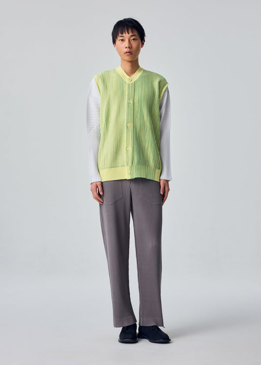 A model wears the HOMME PLISSÉ ISSEY MIYAKE IN THE SHADOW KNIT cardigan.