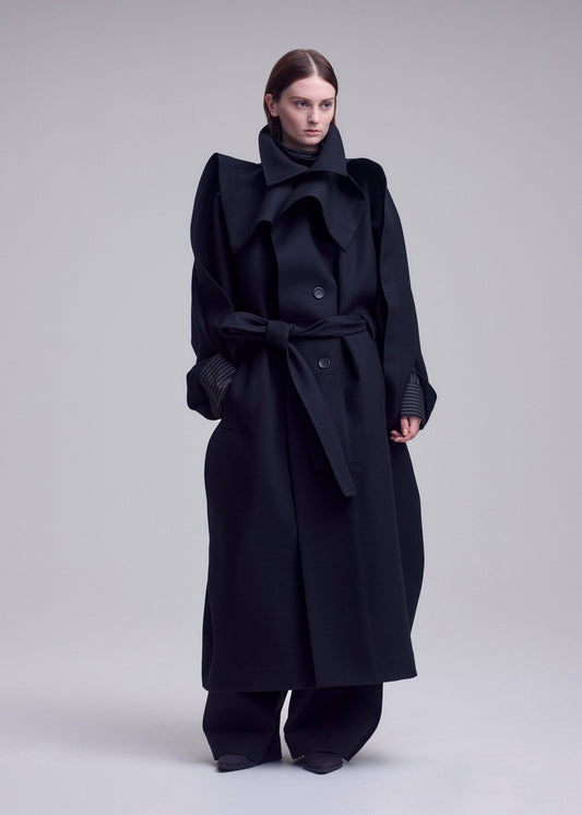 A model wears the ISSEY MIYAKE CALLIGRAPH coat.