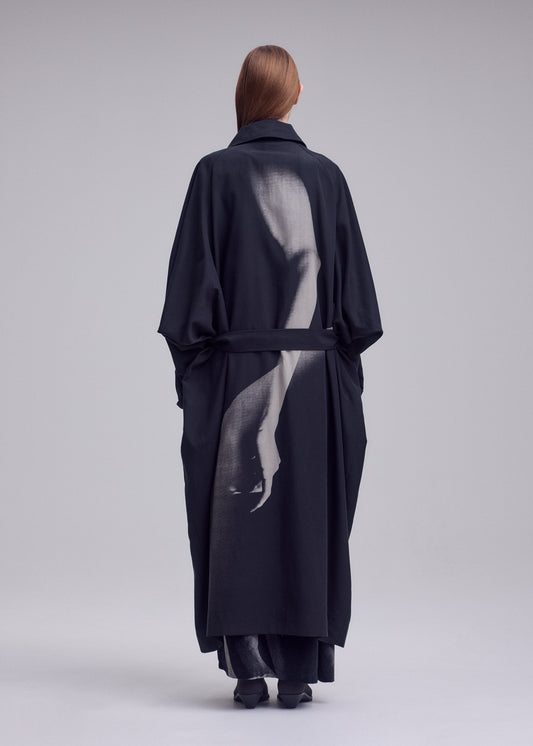 A model wears the ISSEY MIYAKE HANDS OF LOVER coat.