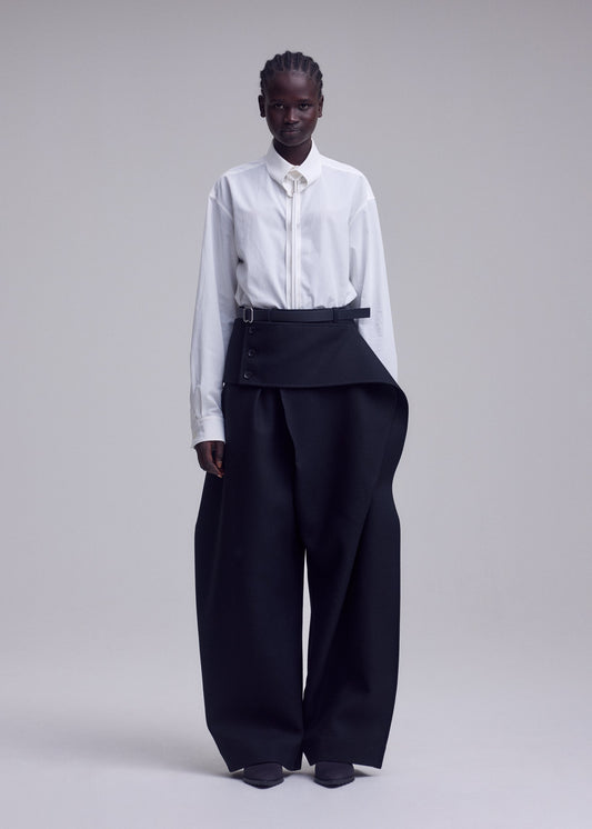A model wears the ISSEY MIYAKE CALLIGRAPH trousers.