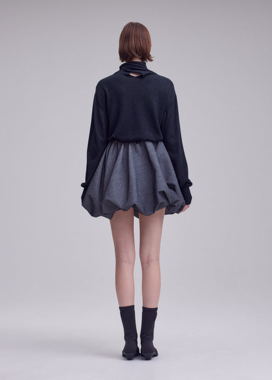 A model wears the ISSEY MIYAKE REFLECTION skirt.