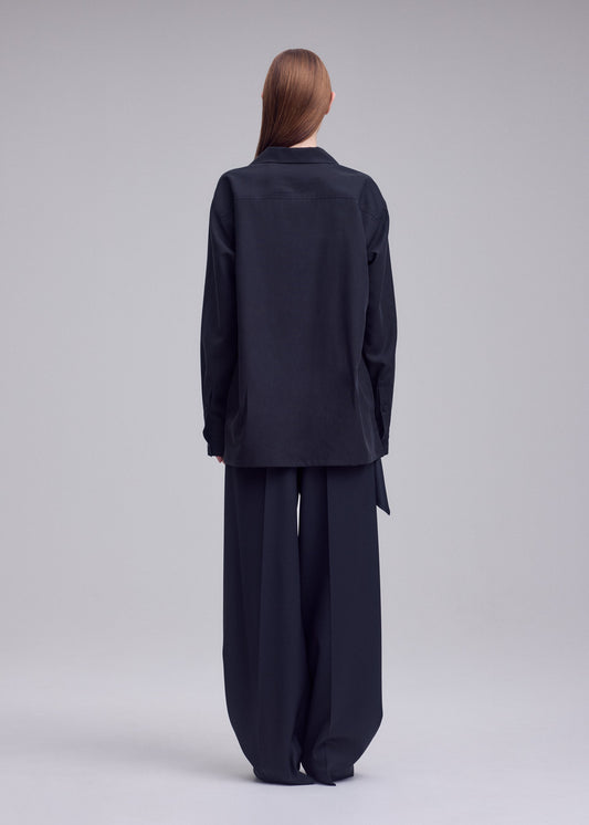 A model wears the ISSEY MIYAKE HANDS OF LOVER shirt.