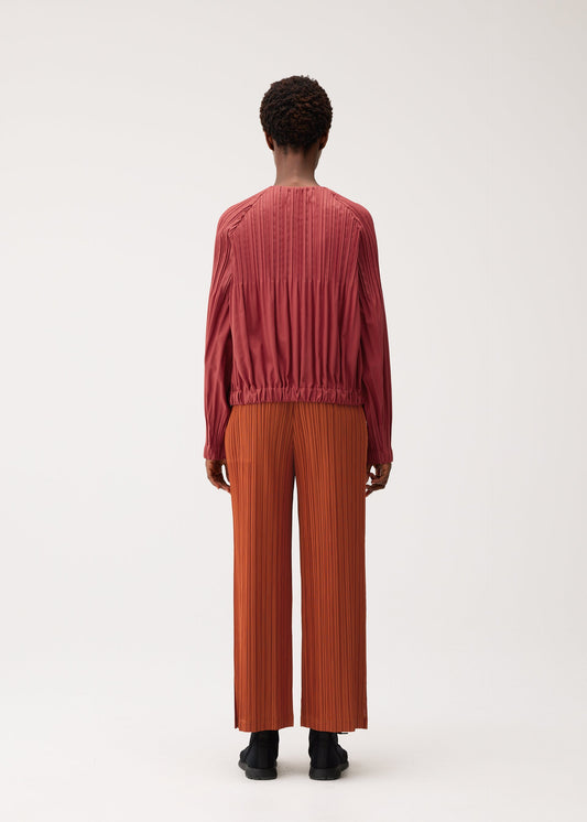A model wears the PLEATS PLEASE ISSEY MIYAKE SMOOTH COAT coat.