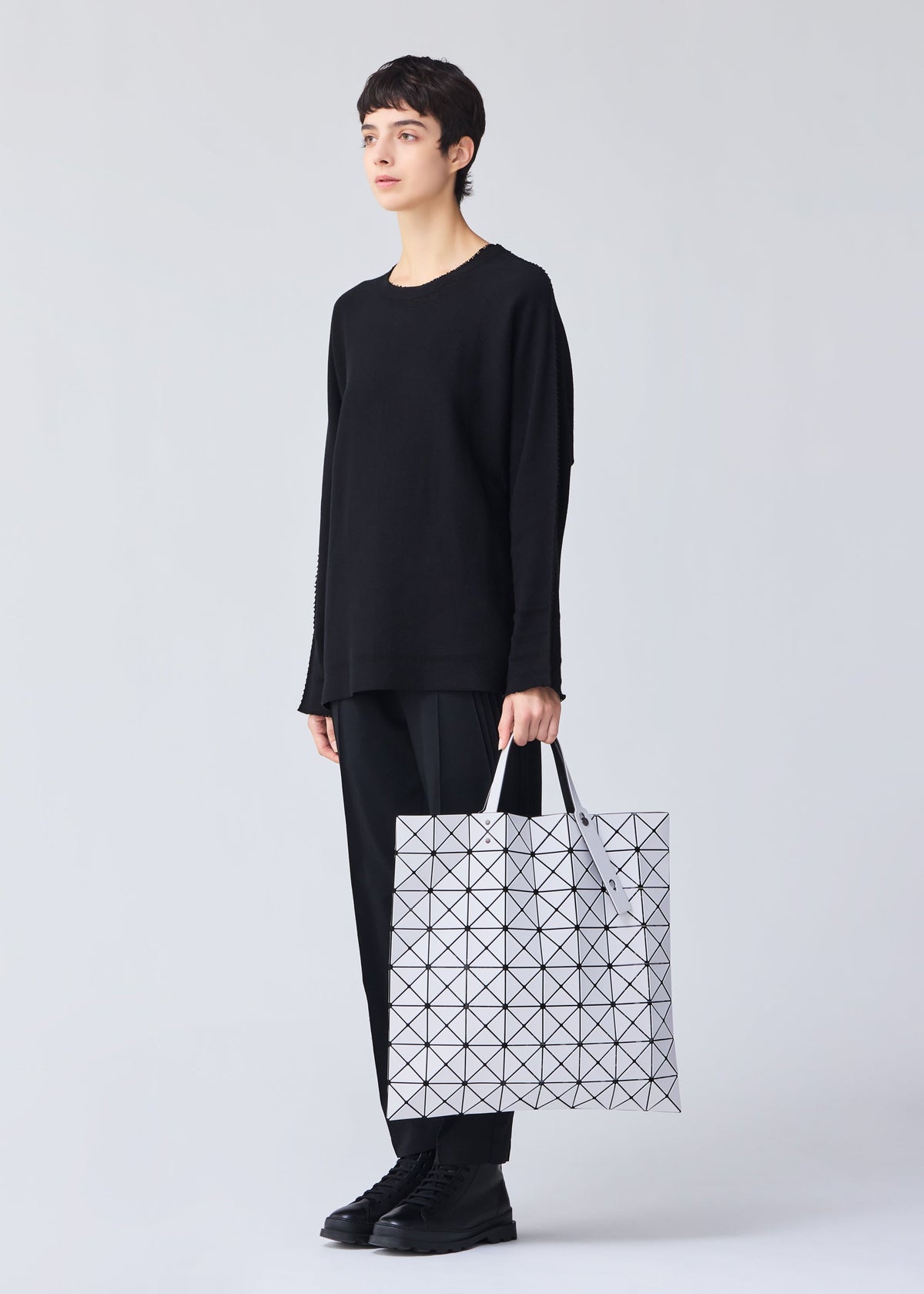 A model wears the Bao Bao Issey Miyake LUCENT MATTE tote bag.