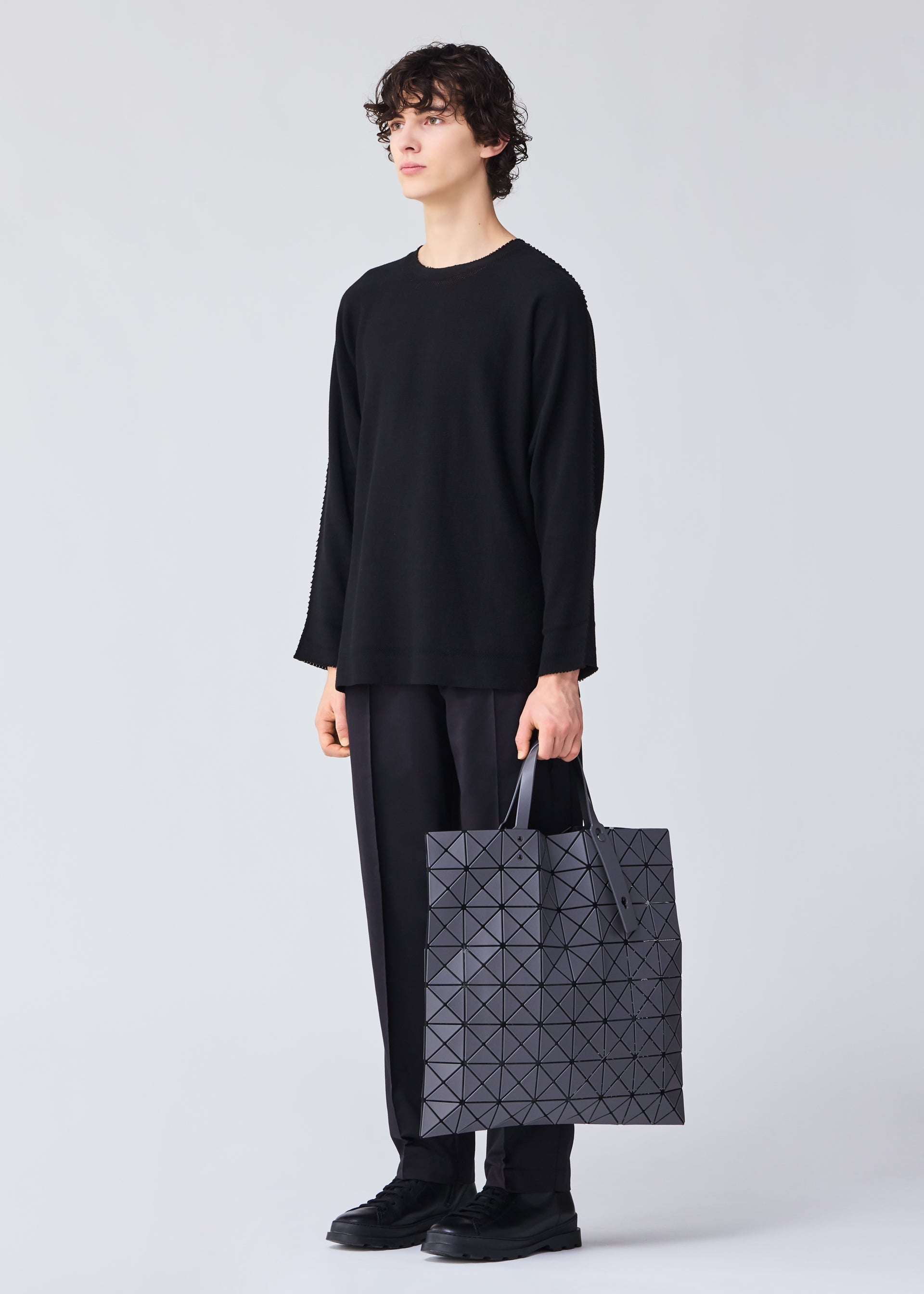 A model wears the Bao Bao Issey Miyake LUCENT MATTE tote bag.