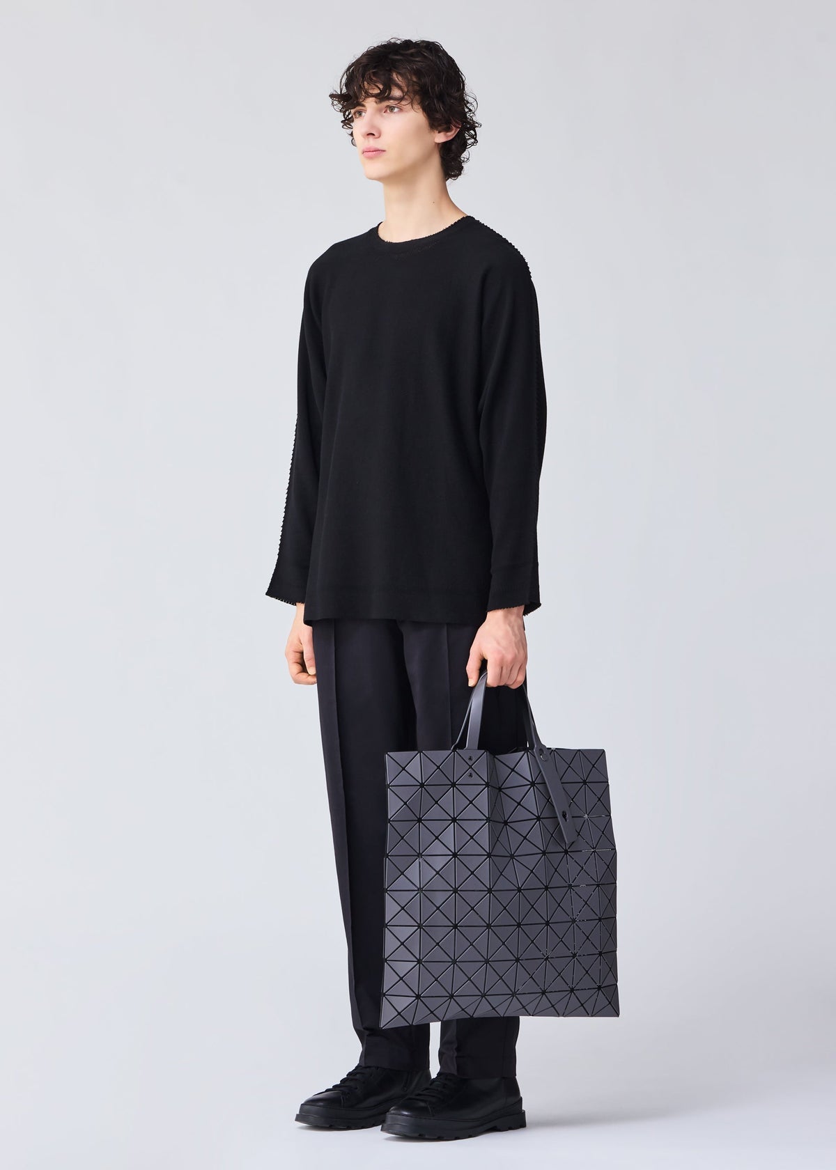 A model wears the Bao Bao Issey Miyake LUCENT MATTE tote bag.