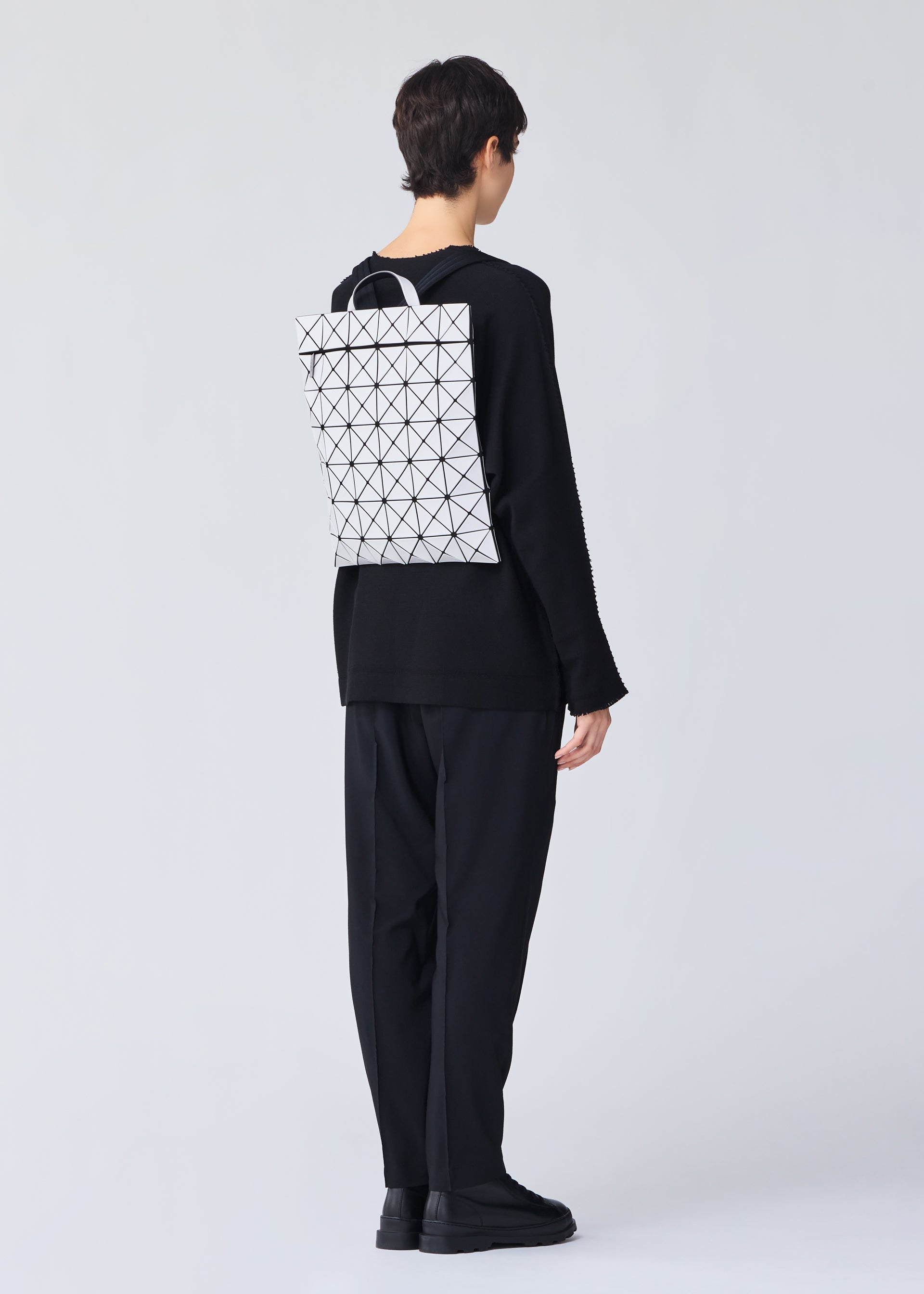 A model wears the Bao Bao Issey Miyake FLAT PACK backpack.
