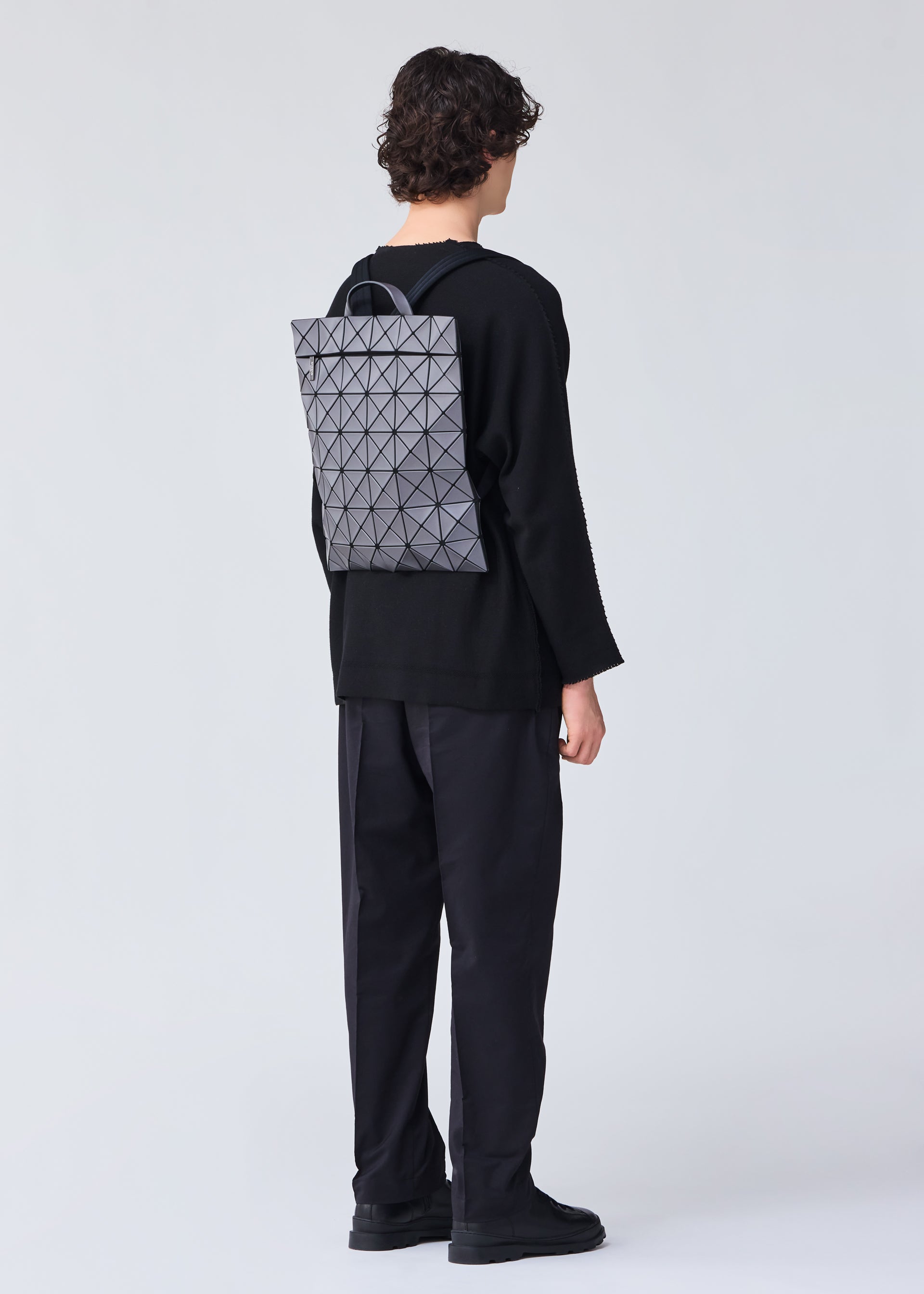 A model wears the Bao Bao Issey Miyake FLAT PACK backpack.
