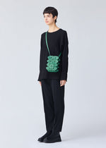 A model wears the BAO BAO ISSEY MIYAKE GROWTH shoulder bag.