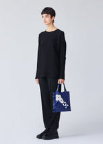 A model wears the Bao Bao Issey Miyake WONDER tote bag.