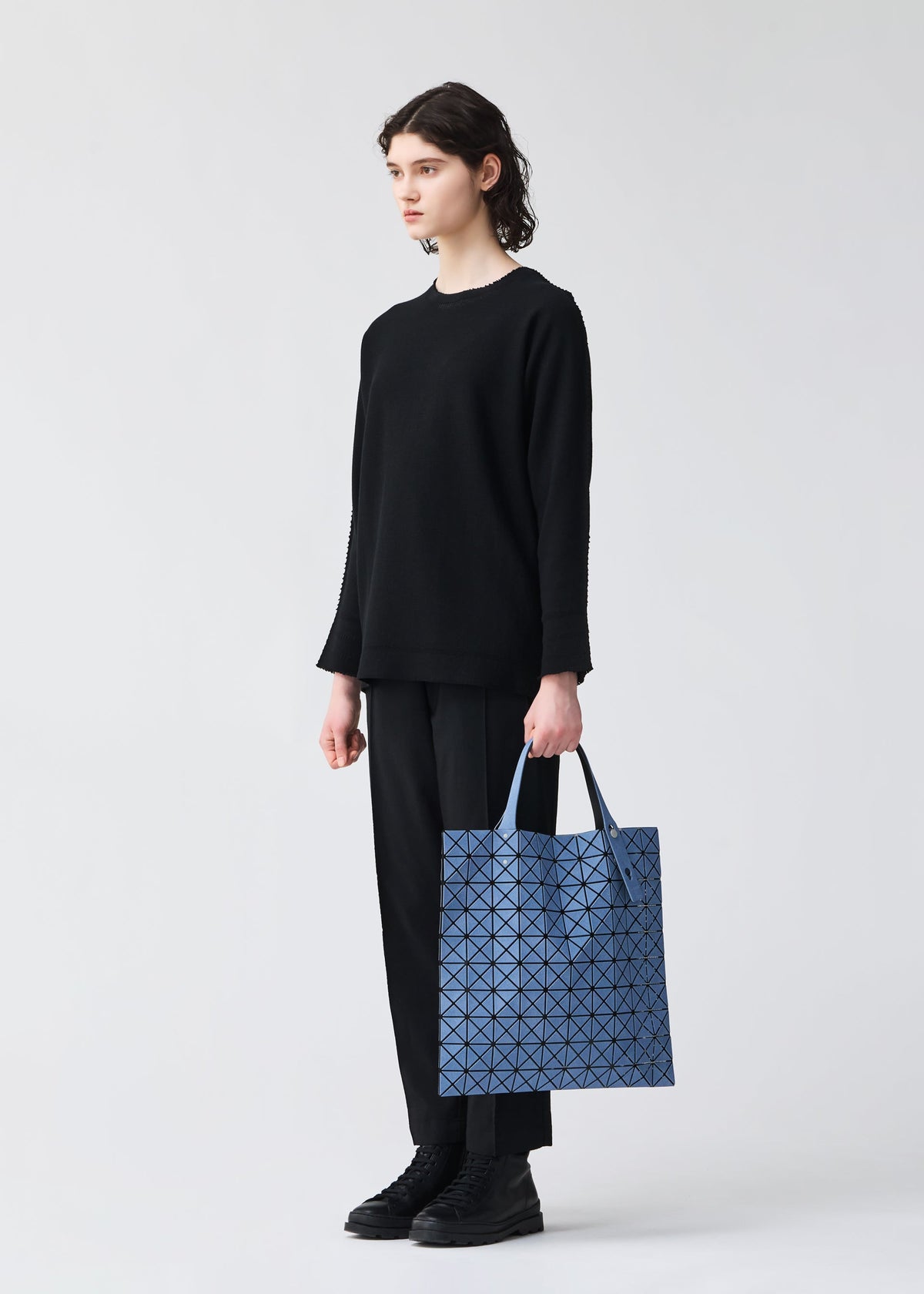 A model wears the BAO BAO ISSEY MIYAKE PRISM DENIM prism-denim-tote-bag10-10-black.