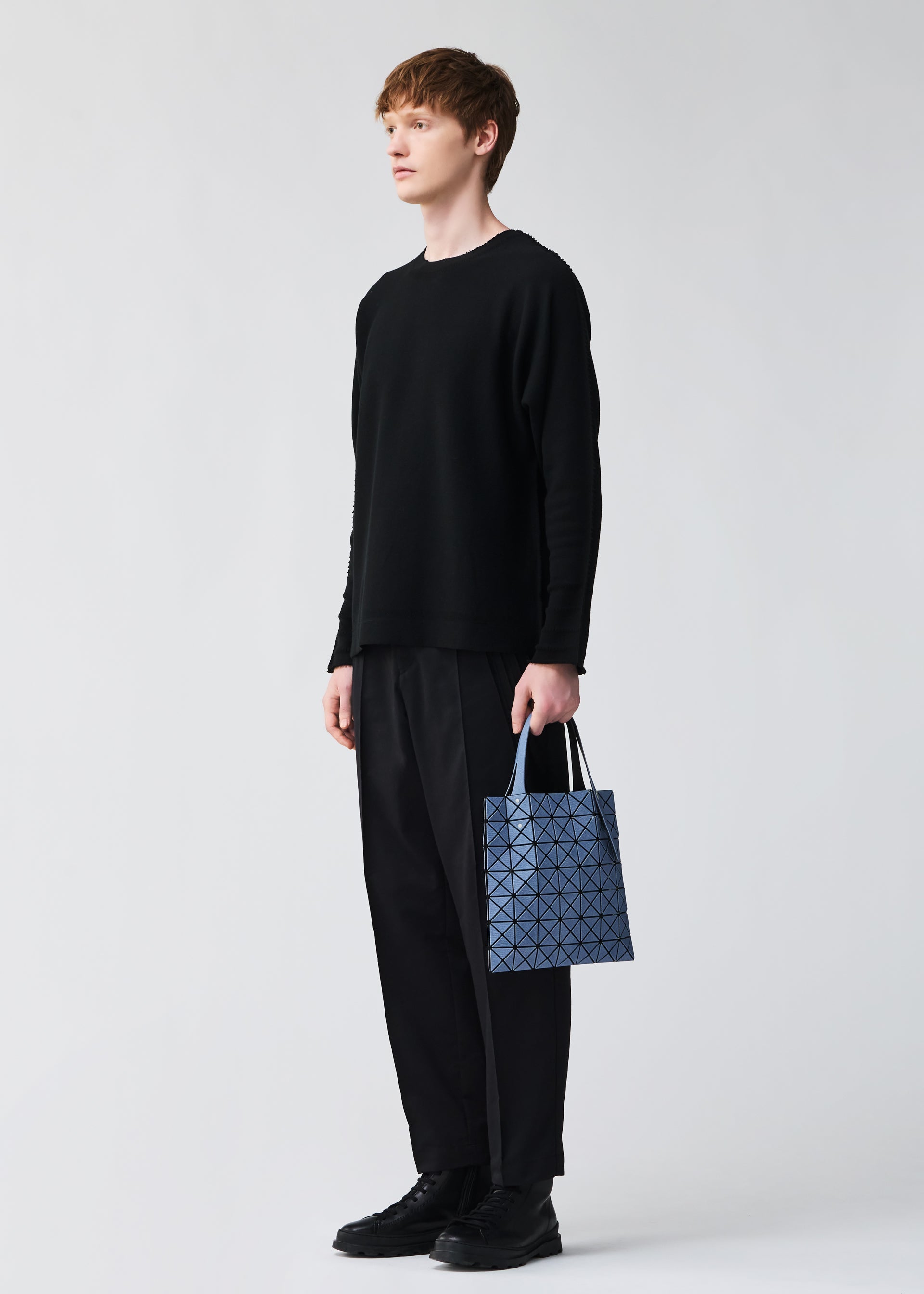 A model wears the BAO BAO ISSEY MIYAKE PRISM DENIM prism-denim-tote-bag7-7-black.