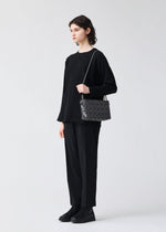 A model wears the BAOBAO ISSEY MIYAKE LOOP ONE TONE shoulder bag.