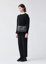 A model wears the BAOBAO ISSEY MIYAKE LOOP ONE TONE shoulder bag.