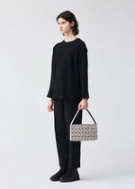 A model wears the BAO BAO ISSEY MIYAKE OBLONG oblong-shoulder-baglarge-matte-black.