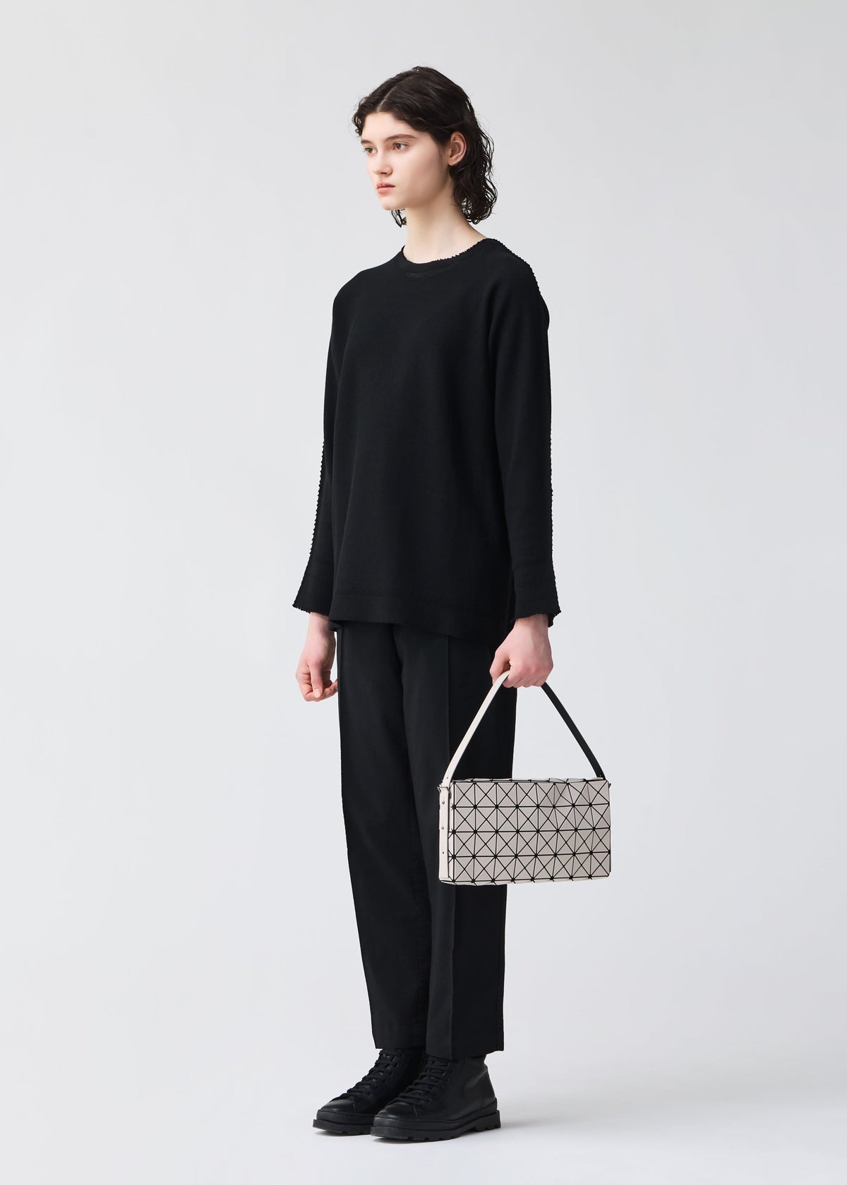 A model wears the BAO BAO ISSEY MIYAKE OBLONG oblong-shoulder-baglarge-khaki.