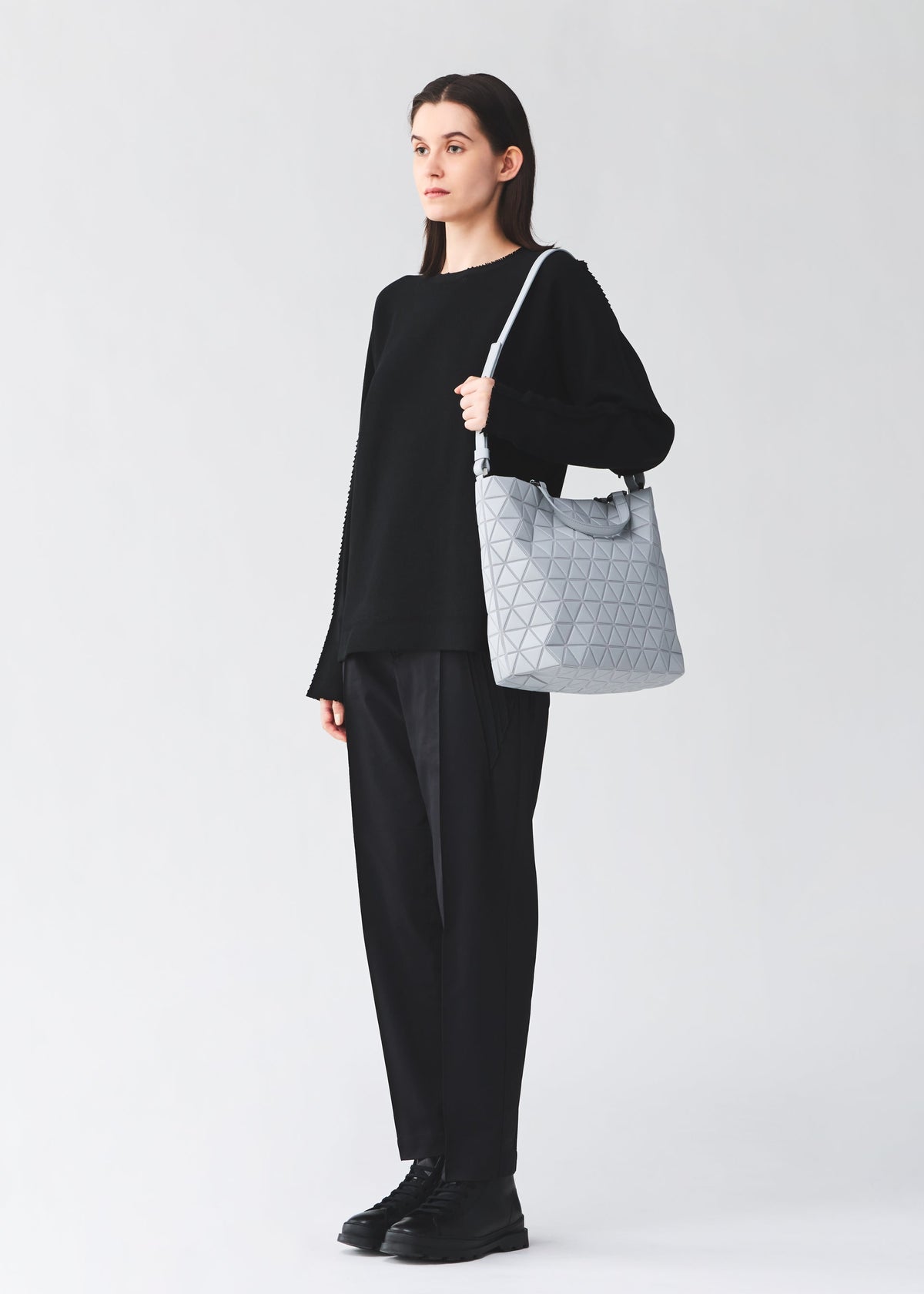 A model wears the BAO BAO ISSEY MIYAKE CRYSTAL MATTE hand bag.