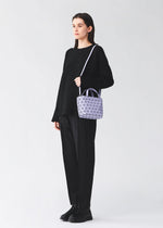 A model wears the BAO BAO ISSEY MIYAKE CRYSTAL MATTE hand bag.