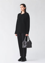 A model wears the BAO BAO ISSEY MIYAKE BOSTON boston-hand-bag-off-white.