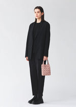 A model wears the BAO BAO ISSEY MIYAKE PRISM PLUS tote bag.