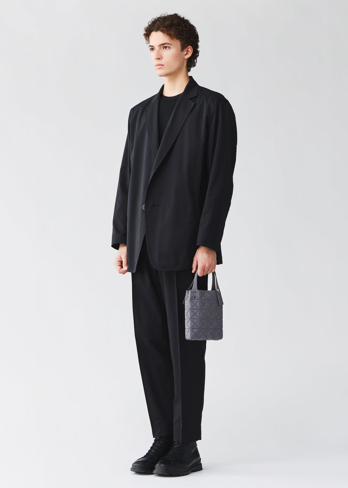 A model wears the BAO BAO ISSEY MIYAKE PRISM PLUS tote bag.
