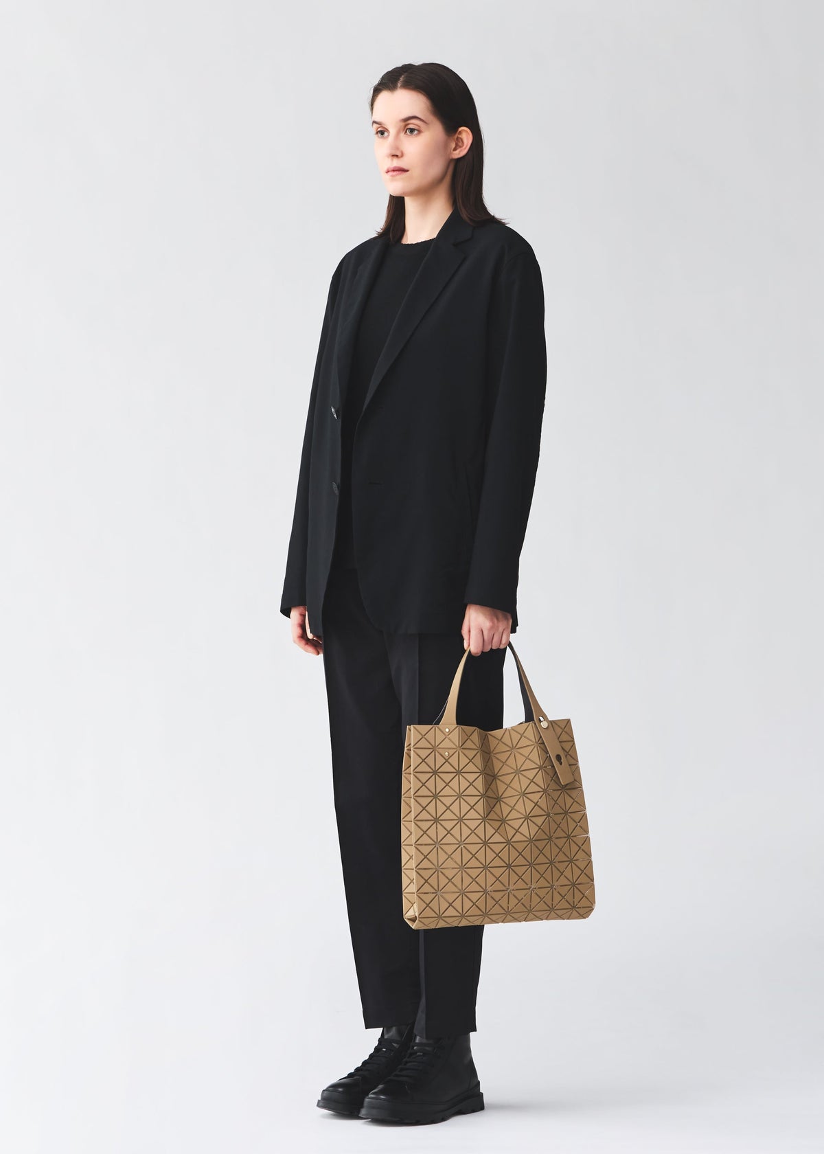 A model wears the BAO BAO ISSEY MIYAKE PRISM PLUS tote bag.