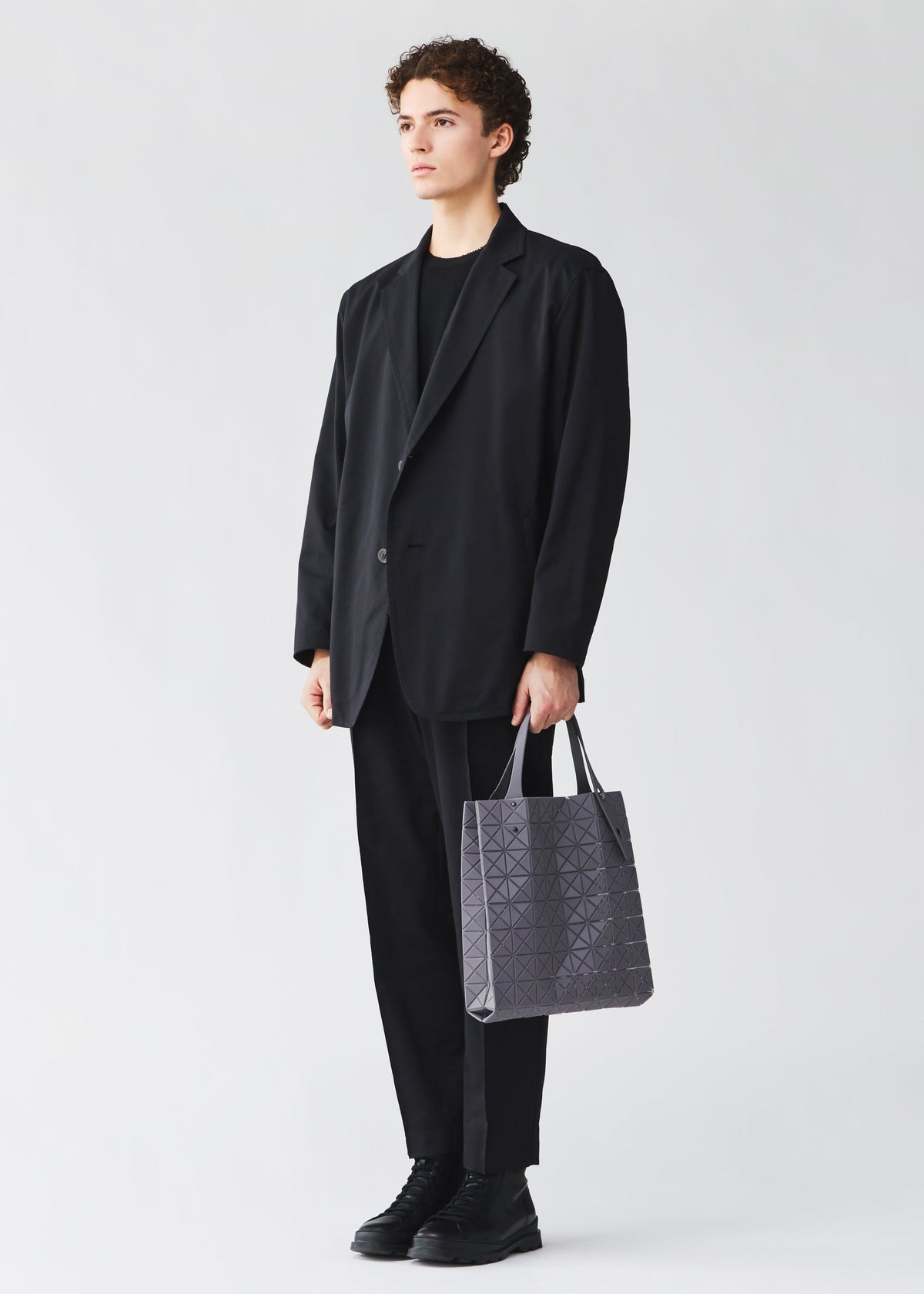 A model wears the BAO BAO ISSEY MIYAKE PRISM PLUS tote bag.