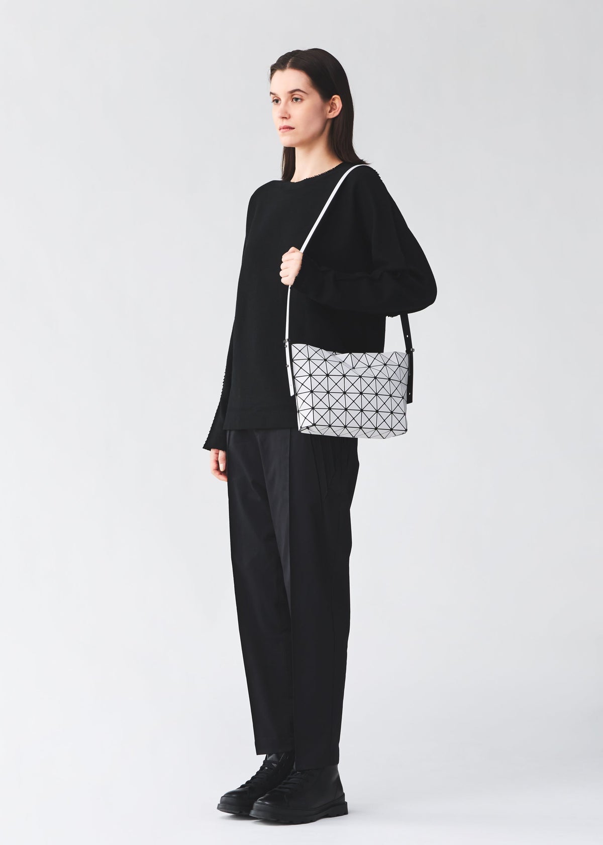 A model wears the BAO BAO ISSEY MIYAKE MUSETTE musette-shoulder-bagsmall-light-grey.