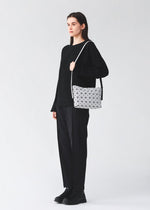 A model wears the BAO BAO ISSEY MIYAKE MUSETTE musette-shoulder-bagsmall-matte-black.