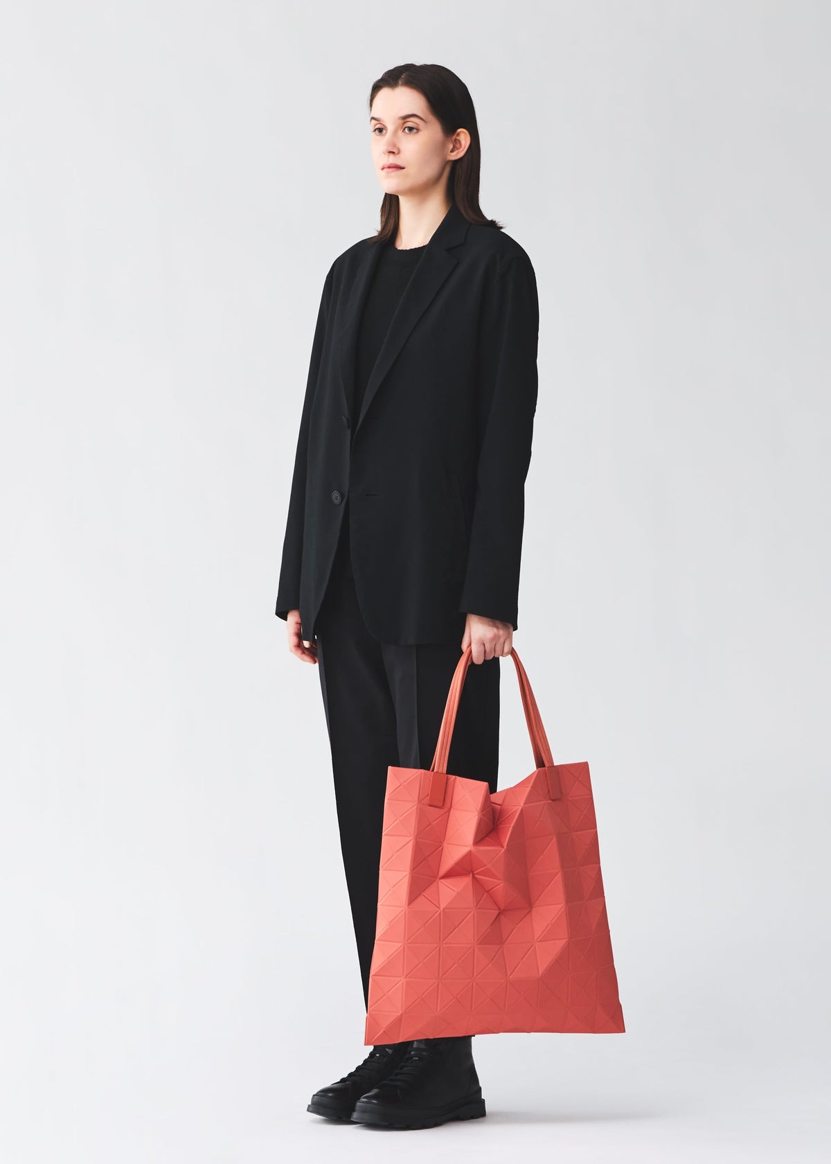 A model wears the BAO BAO ISSEY MIYAKE TRACK tote bag.