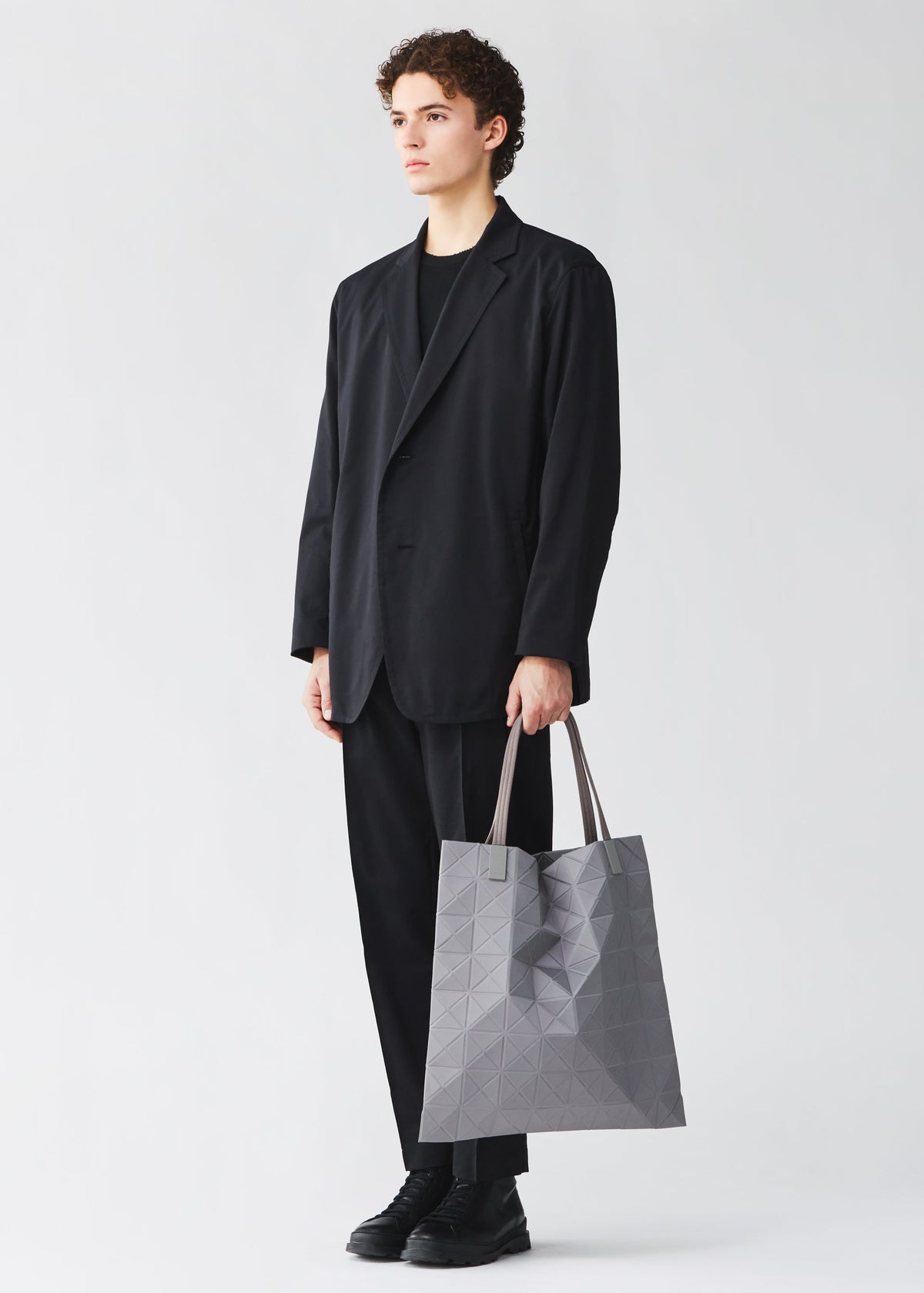 A model wears the BAO BAO ISSEY MIYAKE TRACK tote bag.