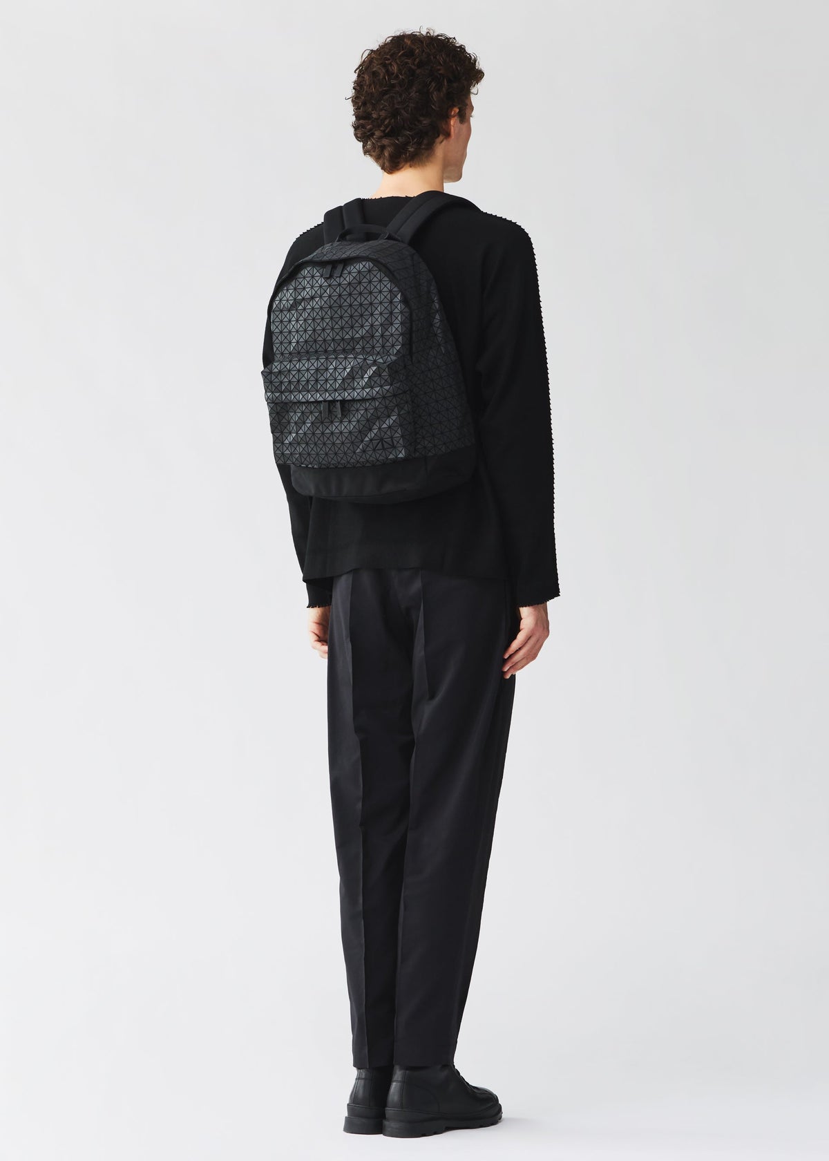 A model wears the BAO BAO ISSEY MIYAKE DAYPACK daypack-backpack-matte-black-fw26.