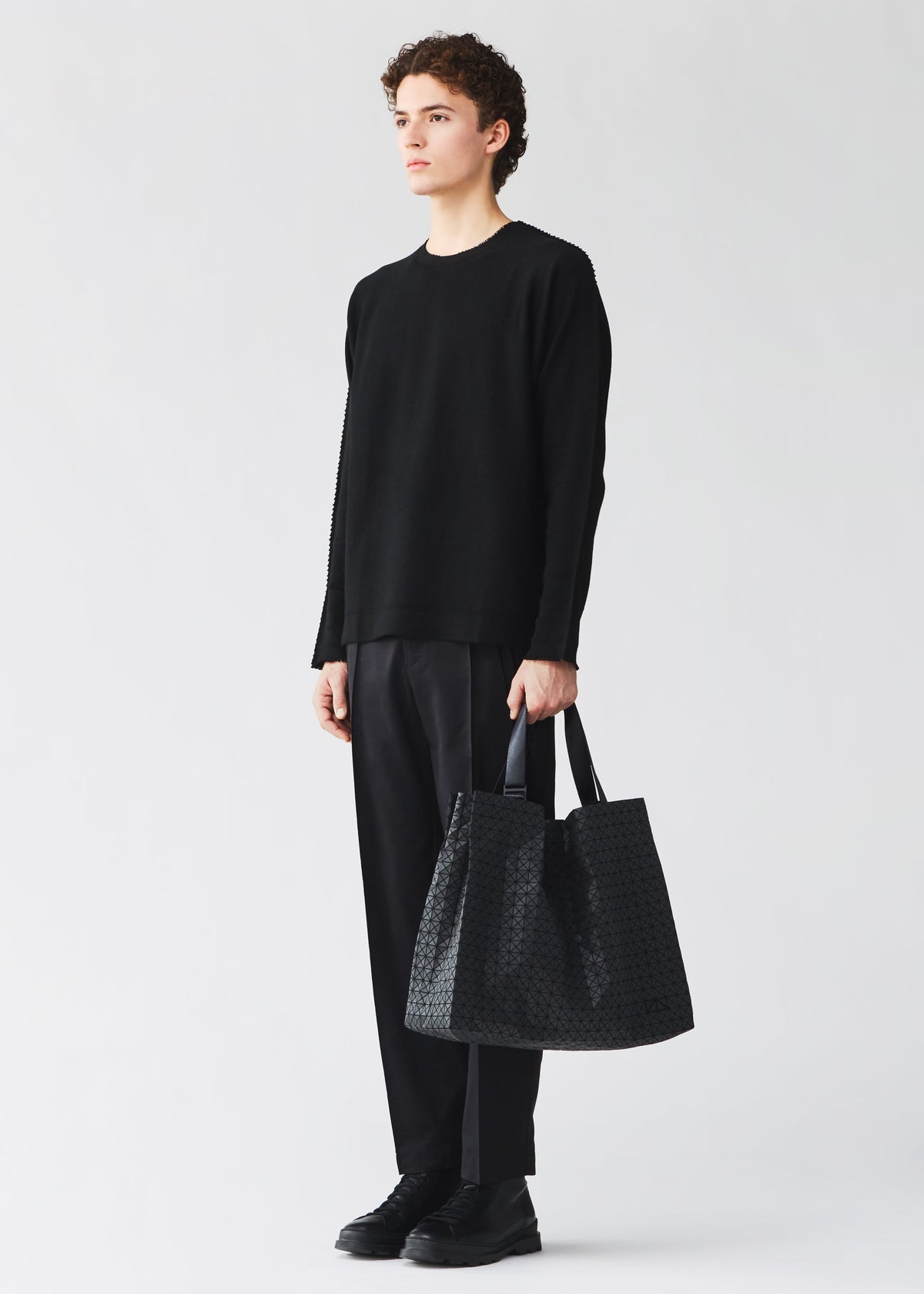 A model wears the BAO BAO ISSEY MIYAKE CART cart-tote-bag-matte-black.