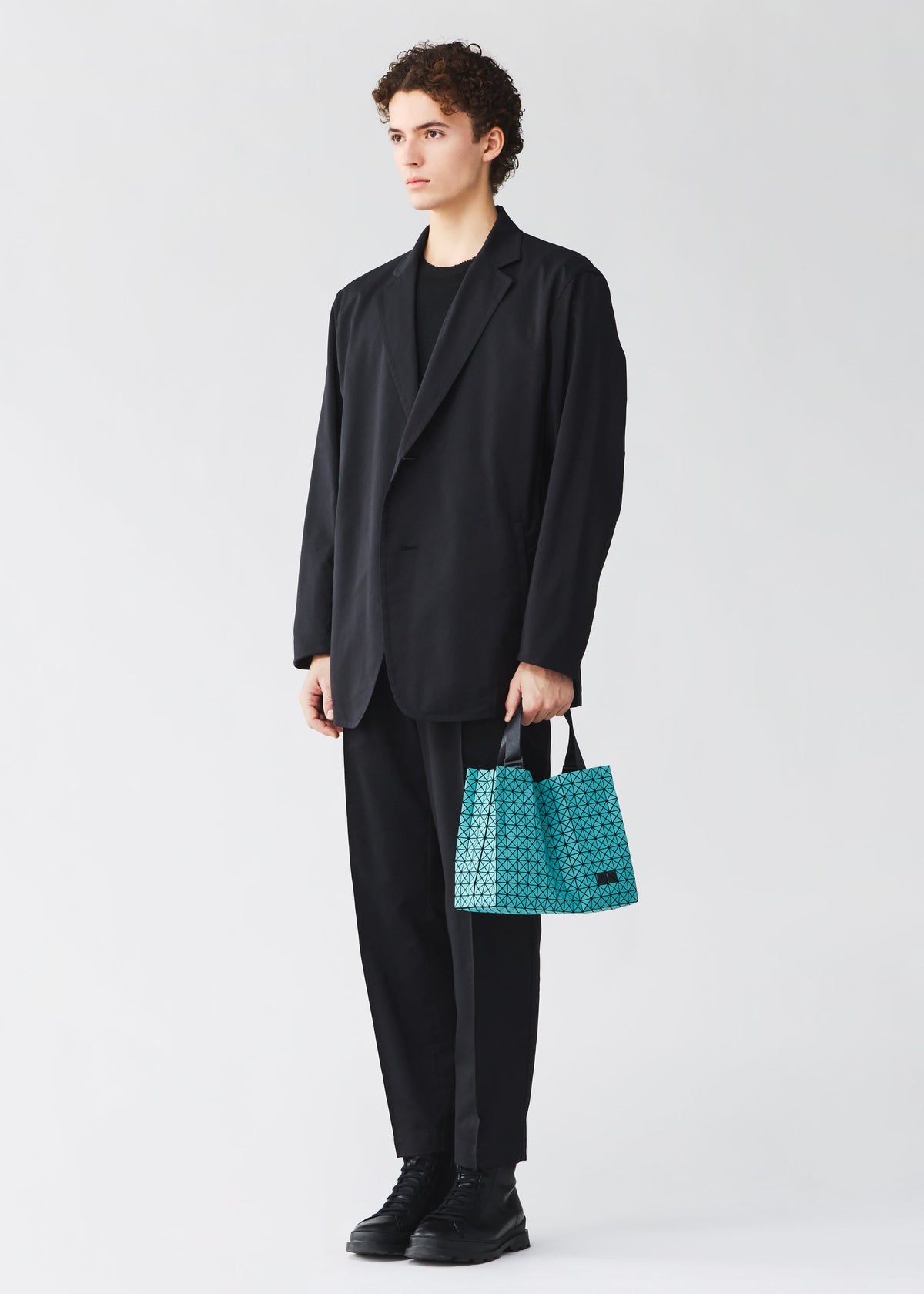 A model wears the BAO BAO ISSEY MIYAKE CART MINI tote bag.