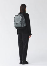A model wears the BAO BAO ISSEY MIYAKE DAYPACK REFLECTOR daypack-reflector-backpack-copper-brown.