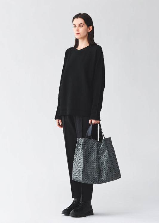 A model wears the BAO BAO ISSEY MIYAKE CART REFLECTOR cart-reflector-tote-bag-1.