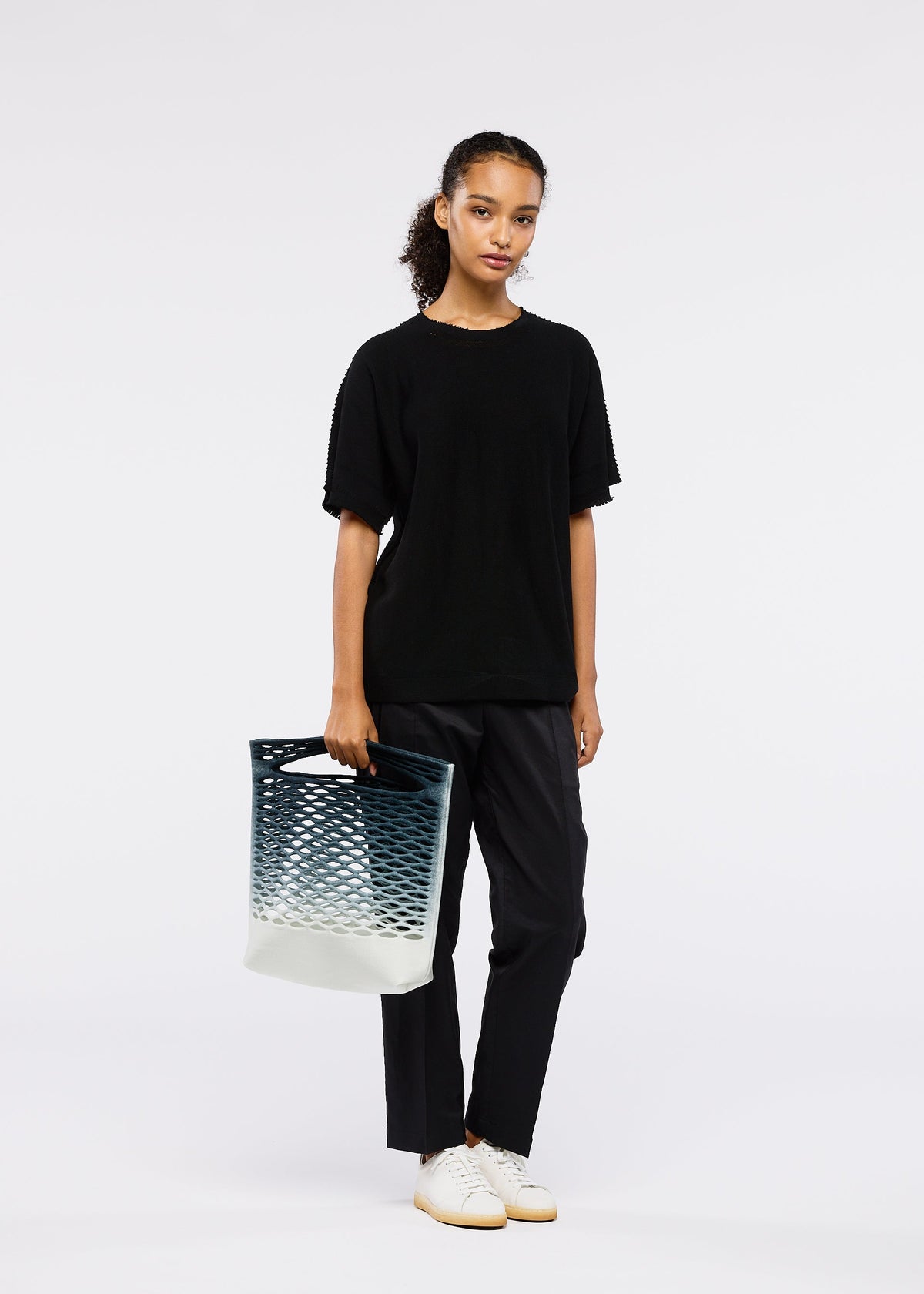 A model wears the GOOD GOODS ISSEY MIYAKE MOKKO NET GRADATION gg66ag37374os.