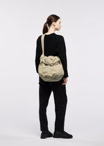 A model wears the GOOD GOODS ISSEY MIYAKE FUWA FUWA fuwa-fuwa-beige-1.