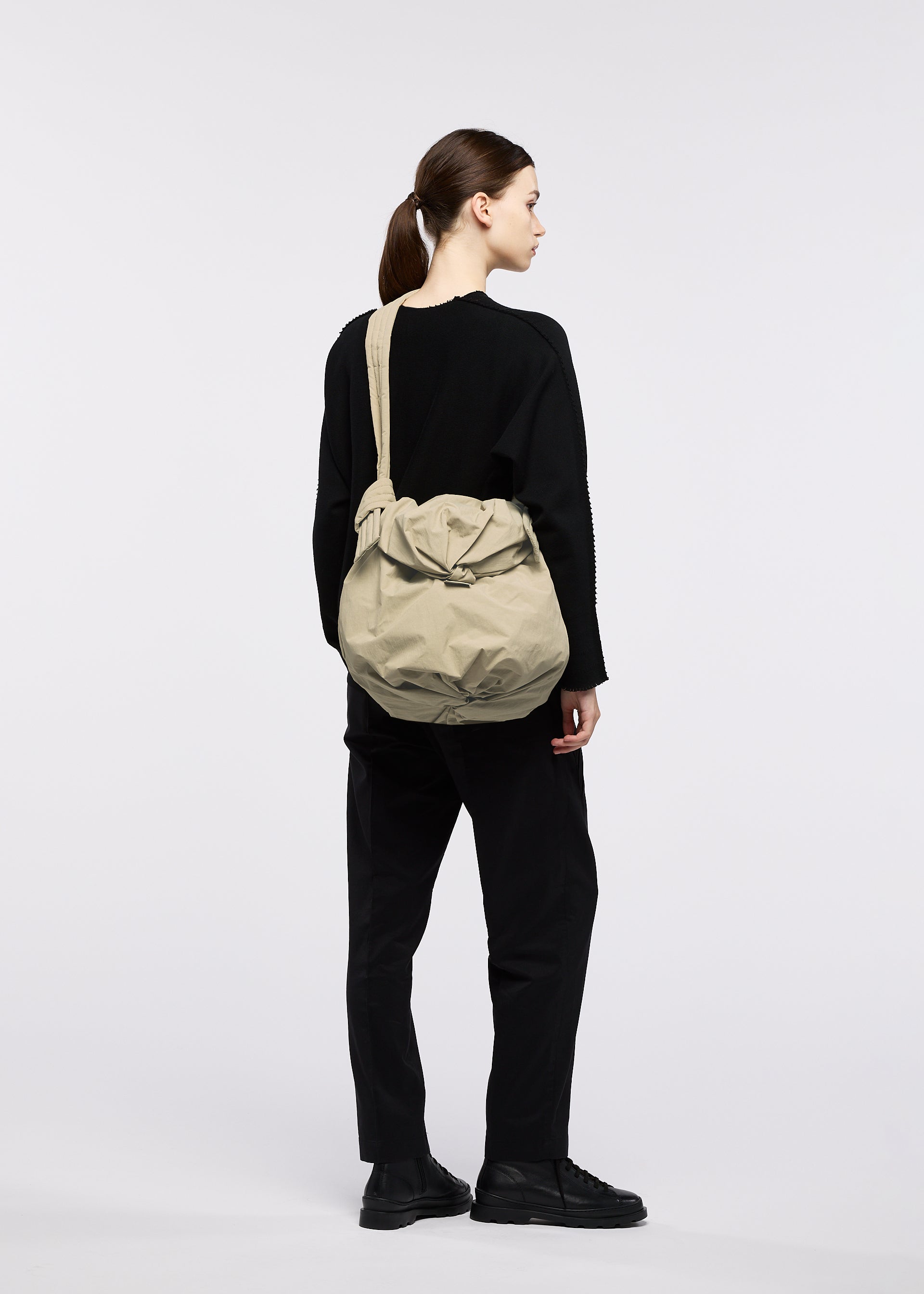A model wears the GOOD GOODS ISSEY MIYAKE FUWA FUWA fuwa-fuwa-beige-1.