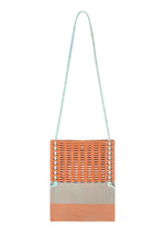 A product shot of the GOOD GOODS ISSEY MIYAKE MOKKO KNOT bag in warm orange mix.