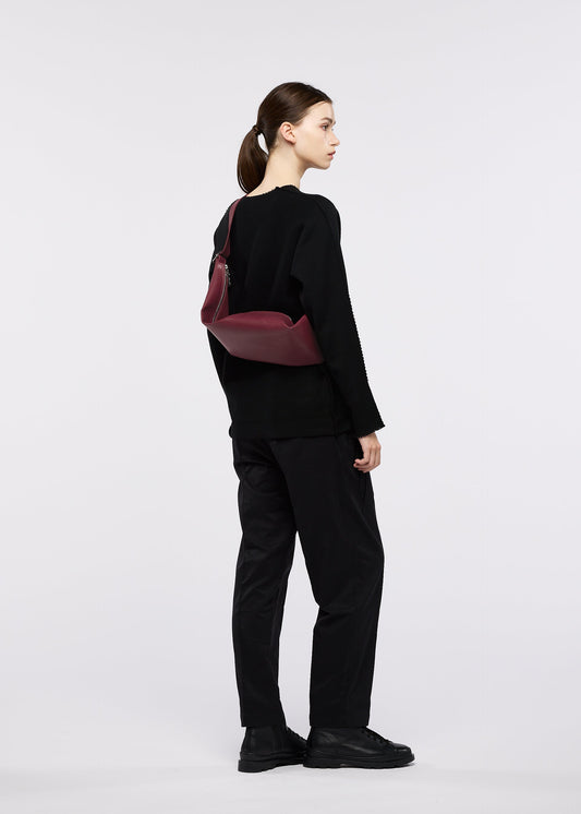 A model wears the GOOD GOODS ISSEY MIYAKE LEAF bag.