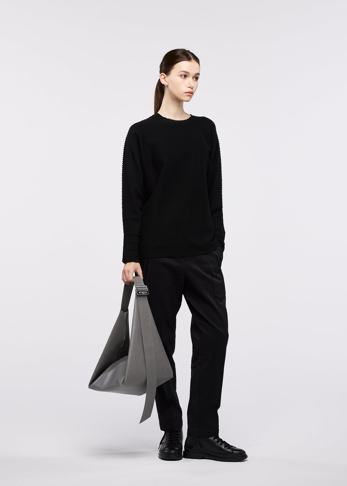 A model wears the GOOD GOODS ISSEY MIYAKE LEAF bag.