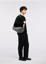 A model wears the GOOD GOODS ISSEY MIYAKE LEAF bag.
