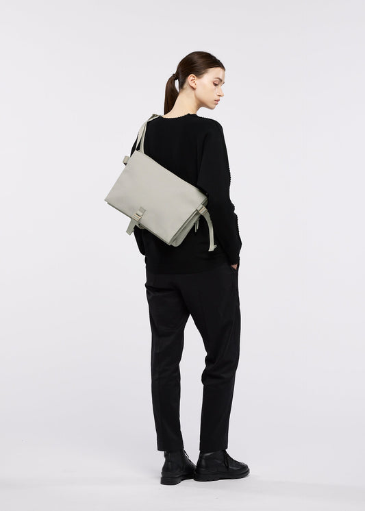 A model wears the GOOD GOODS ISSEY MIYAKE JABARA bag.